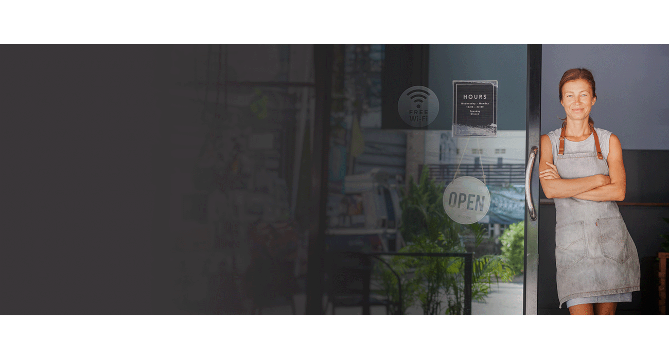 Small business employee standing in the doorway of an open business with WiFi 