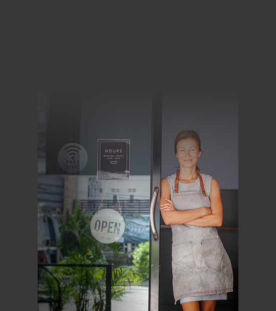 Small business employee standing in the doorway of an open business with WiFi 